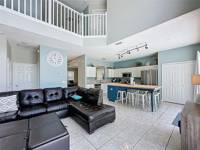 1426 Park Park, Haines City, FL 33844 - living area with a textured ceiling, a high ceiling, light tile patterned flooring, and arched walkways