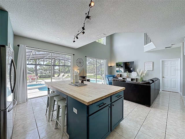1426 Park Park, Haines City, FL 33844 - kitchen featuring wood counters, freestanding refrigerator, track lighting, light tile patterned floors, and a breakfast bar