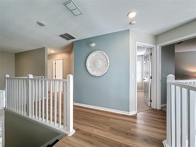 1426 Park Park, Haines City, FL 33844 - hallway featuring an upstairs landing, wood finished floors, and a textured ceiling