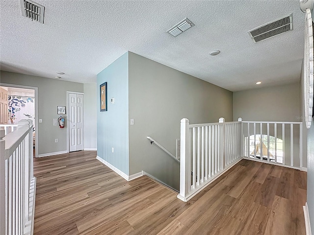 1426 Park Park, Haines City, FL 33844 - hall featuring wood finished floors, an upstairs landing, and a textured ceiling