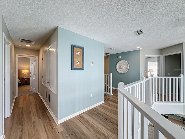 1426 Park Park, Haines City, FL 33844 - hall with an upstairs landing, wood finished floors, and a textured ceiling
