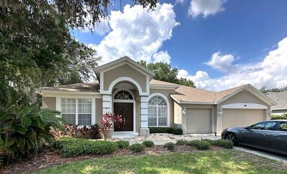 401 Chinahill Ct, Apopka, FL 32712 - single story home with an attached garage, stucco siding, and driveway