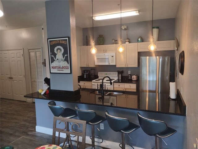 8101 Coconut Palm Way Unit 303, Kissimmee, FL 34747 - kitchen featuring white appliances, white cabinets, a breakfast bar area, and a sink