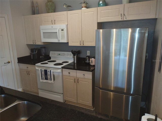 8101 Coconut Palm Way Unit 303, Kissimmee, FL 34747 - kitchen featuring white appliances, dark countertops, a sink, and white cabinets