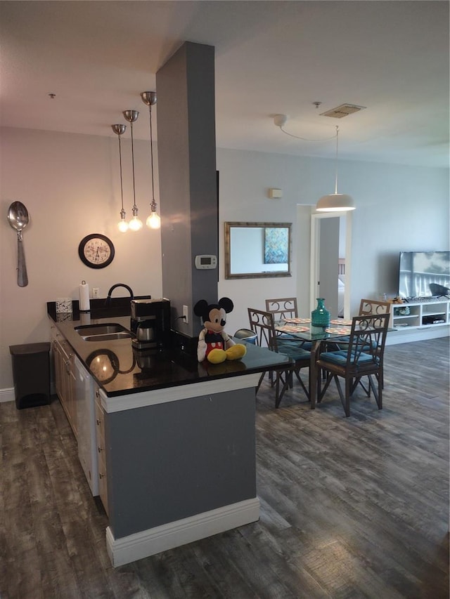 8101 Coconut Palm Way Unit 303, Kissimmee, FL 34747 - kitchen featuring a sink, dark countertops, dishwasher, dark wood-style floors, and pendant lighting