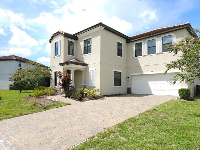 191 Aidans Lndg, Haines City, FL 33844 - view of front of home featuring stucco siding, a garage, driveway, and a front lawn
