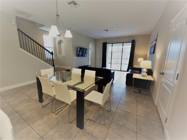 191 Aidans Lndg, Haines City, FL 33844 - dining room featuring arched walkways, healthy amount of natural light, stairs, and light tile patterned flooring
