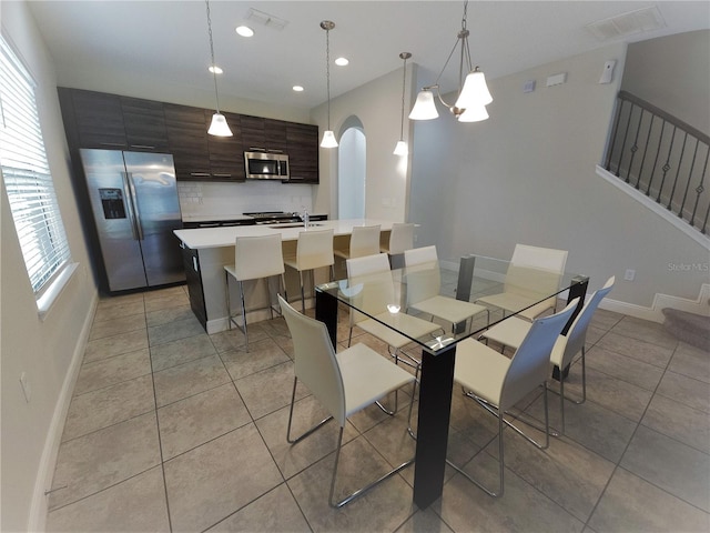 191 Aidans Lndg, Haines City, FL 33844 - dining area featuring light tile patterned flooring, stairs, baseboards, arched walkways, and recessed lighting
