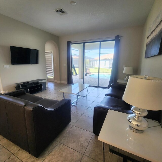 191 Aidans Lndg, Haines City, FL 33844 - living room featuring light tile patterned floors and arched walkways
