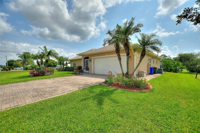 4236 Lakewood Rd, Sebring, FL 33875 - rear view of house with stucco siding, decorative driveway, an attached garage, and central AC
