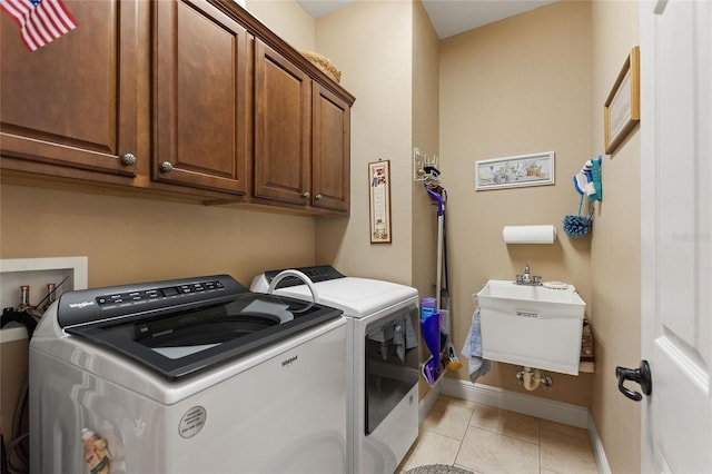 4236 Lakewood Rd, Sebring, FL 33875 - laundry room with washing machine and clothes dryer, baseboards, cabinet space, and light tile patterned floors