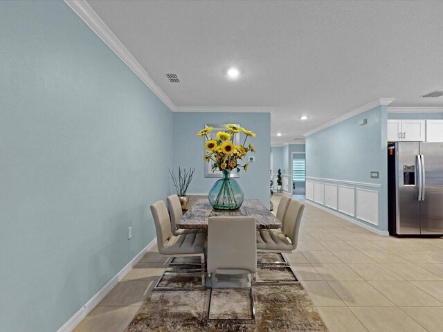1278 Asher Mason Ave, Kissimmee, FL 34744 - dining room featuring crown molding, light tile patterned floors, recessed lighting, baseboards, and a wainscoted wall