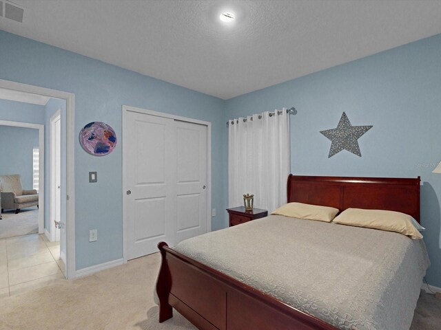 1278 Asher Mason Ave, Kissimmee, FL 34744 - bedroom with light carpet, baseboards, a closet, and a textured ceiling