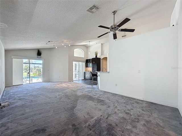 1428 Park Pl, Haines City, FL 33844 - unfurnished living room featuring vaulted ceiling, a textured ceiling, carpet, and a ceiling fan