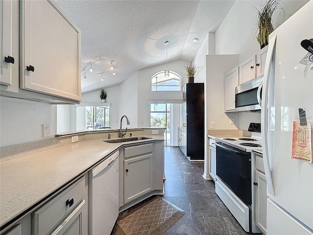 1428 Park Pl, Haines City, FL 33844 - kitchen with white appliances, vaulted ceiling, a peninsula, a textured ceiling, and dark stone finish floors