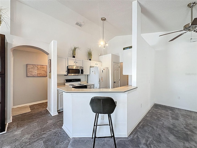 1428 Park Pl, Haines City, FL 33844 - kitchen with white appliances, a ceiling fan, arched walkways, light countertops, and high vaulted ceiling