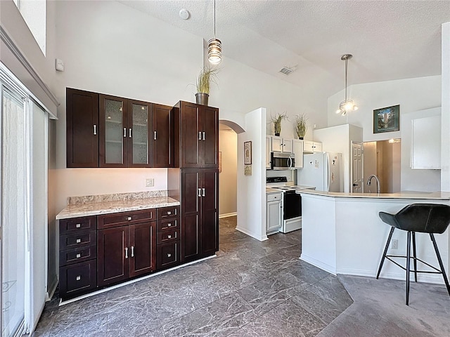 1428 Park Pl, Haines City, FL 33844 - kitchen featuring white appliances, high vaulted ceiling, arched walkways, glass insert cabinets, and light countertops