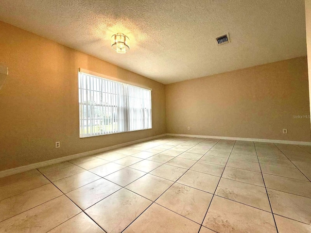1001 Plantation Dr Unit E1, Kissimmee, FL 34741 - spare room with light tile patterned floors, a textured ceiling, and baseboards