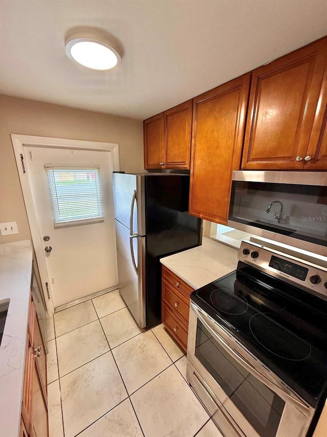 1001 Plantation Dr Unit E1, Kissimmee, FL 34741 - kitchen featuring appliances with stainless steel finishes, brown cabinets, and light countertops