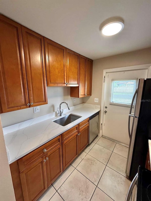 1001 Plantation Dr Unit E1, Kissimmee, FL 34741 - kitchen with a sink, appliances with stainless steel finishes, brown cabinets, and light stone counters