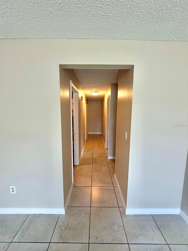 1001 Plantation Dr Unit E1, Kissimmee, FL 34741 - corridor featuring baseboards, a textured ceiling, and light tile patterned floors