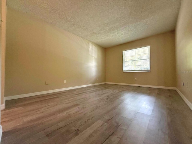 1001 Plantation Dr Unit E1, Kissimmee, FL 34741 - empty room with a textured ceiling, wood finished floors, and baseboards