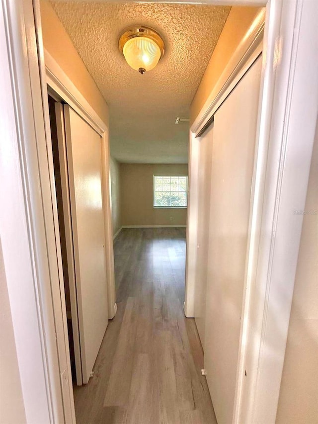 1001 Plantation Dr Unit E1, Kissimmee, FL 34741 - corridor with light wood finished floors, a textured ceiling, and baseboards