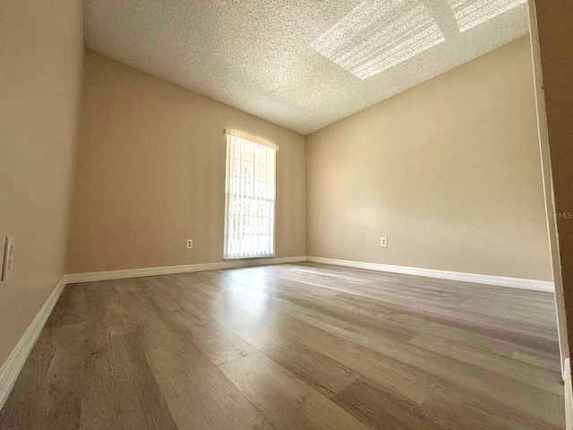 1001 Plantation Dr Unit E1, Kissimmee, FL 34741 - empty room with wood finished floors, a textured ceiling, and baseboards