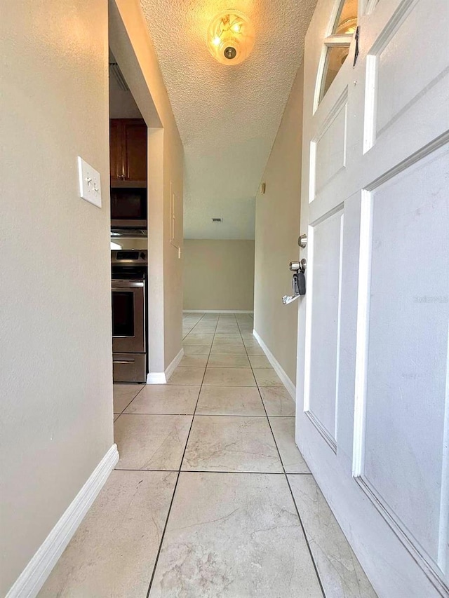 1001 Plantation Dr Unit E1, Kissimmee, FL 34741 - corridor featuring a textured ceiling and baseboards