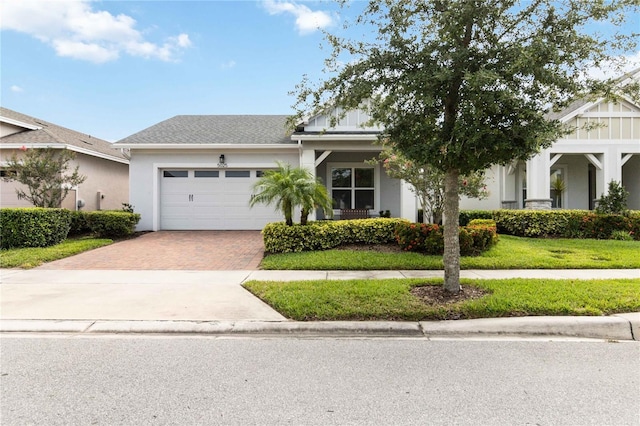 5025 Sunfalls Ave, Saint Cloud, FL 34772 - view of front of property featuring decorative driveway, a garage, stucco siding, and a front lawn