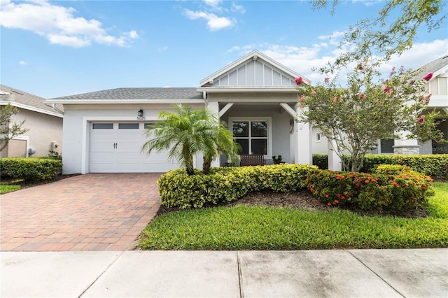 5025 Sunfalls Ave, Saint Cloud, FL 34772 - view of front facade with decorative driveway, an attached garage, and stucco siding