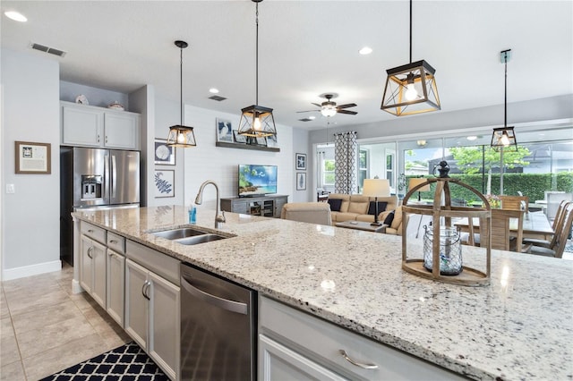 5025 Sunfalls Ave, Saint Cloud, FL 34772 - kitchen featuring a sink, stainless steel dishwasher, baseboards, light stone countertops, and pendant lighting