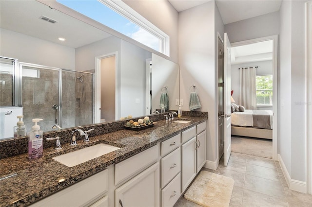 5025 Sunfalls Ave, Saint Cloud, FL 34772 - ensuite bathroom with double vanity, a stall shower, baseboards, and tile patterned floors