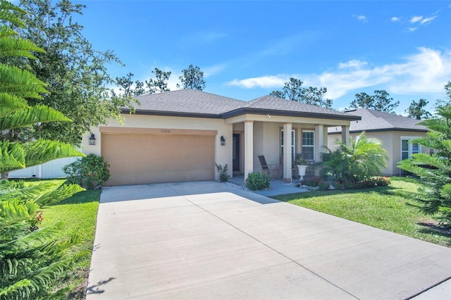 1096 Roberta Rd, Lake Wales, FL 33853 - view of front of house featuring a garage, stucco siding, a front lawn, concrete driveway, and a porch