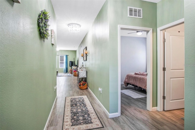 1096 Roberta Rd, Lake Wales, FL 33853 - hallway with wood finished floors, a textured wall, baseboards, and a chandelier