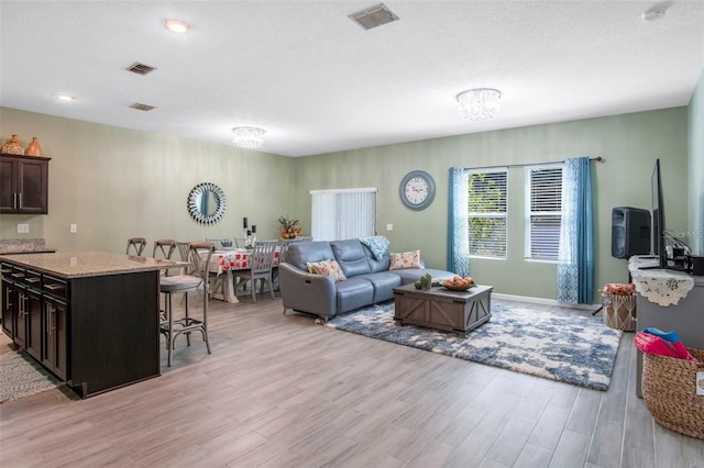1096 Roberta Rd, Lake Wales, FL 33853 - living room featuring light wood finished floors and a chandelier