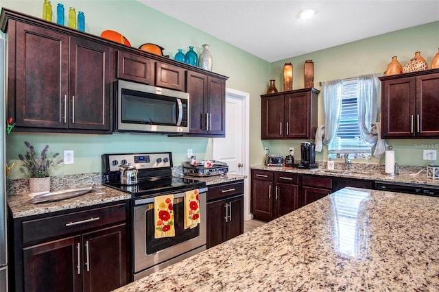 1096 Roberta Rd, Lake Wales, FL 33853 - kitchen with appliances with stainless steel finishes, a sink, light stone counters, and dark brown cabinets