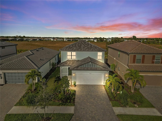 6288 Winding Pine Dr, Nokomis, FL 34275 - traditional home with decorative driveway, an attached garage, stucco siding, and a tiled roof