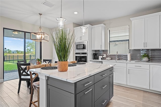 6288 Winding Pine Dr, Nokomis, FL 34275 - kitchen featuring appliances with stainless steel finishes, gray cabinetry, plenty of natural light, white cabinetry, and recessed lighting