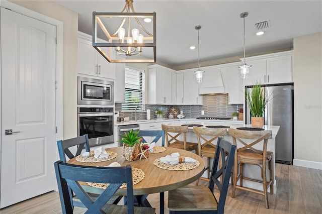 6288 Winding Pine Dr, Nokomis, FL 34275 - kitchen with stainless steel appliances, light countertops, white cabinetry, light wood-style flooring, and recessed lighting