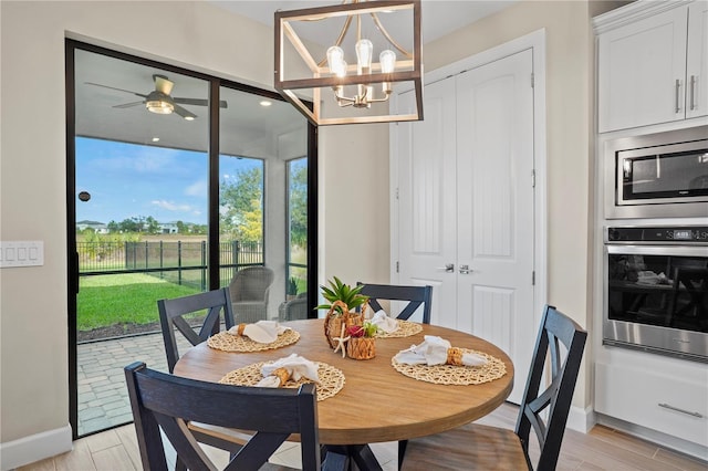 6288 Winding Pine Dr, Nokomis, FL 34275 - dining space with baseboards, a chandelier, and light wood finished floors