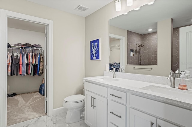 6288 Winding Pine Dr, Nokomis, FL 34275 - bathroom with double vanity, toilet, a spacious closet, a tile shower, and marble look tiles