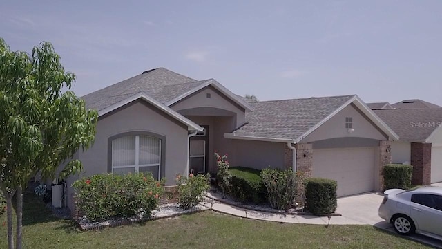 939 Jaybee Ave, Davenport, FL 33897 - ranch-style home featuring a garage, concrete driveway, stucco siding, a shingled roof, and brick siding