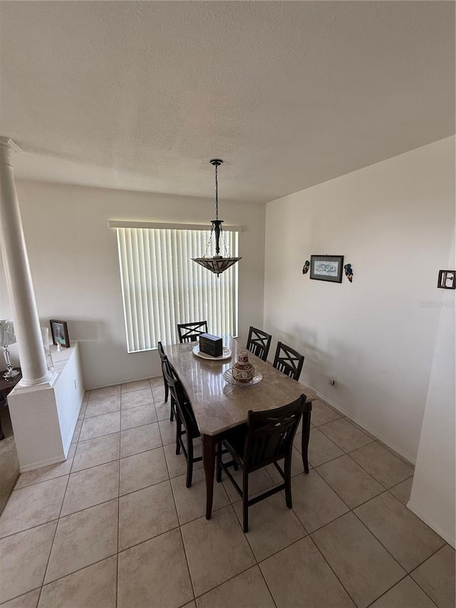 939 Jaybee Ave, Davenport, FL 33897 - dining space featuring decorative columns, light tile patterned floors, a chandelier, and a textured ceiling