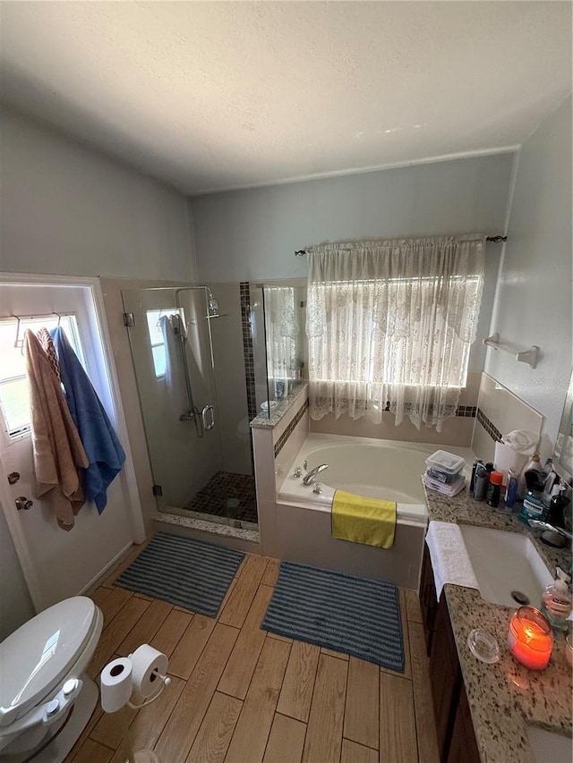 939 Jaybee Ave, Davenport, FL 33897 - full bathroom featuring wood finish floors, a bath, a stall shower, toilet, and vanity