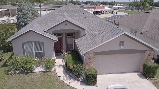 939 Jaybee Ave, Davenport, FL 33897 - ranch-style home with an attached garage, driveway, stucco siding, and a shingled roof