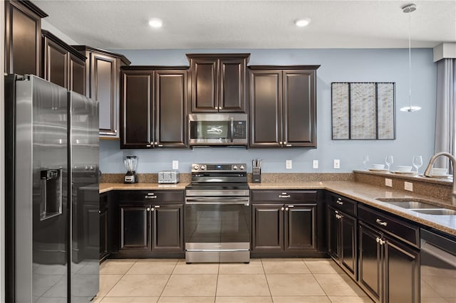 1456 Belle Terre Rd, Davenport, FL 33896 - kitchen featuring stainless steel appliances, a sink, light stone counters, light tile patterned floors, and dark brown cabinetry