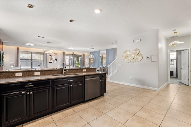 1456 Belle Terre Rd, Davenport, FL 33896 - kitchen with a sink, stainless steel dishwasher, dark cabinetry, light tile patterned floors, and baseboards