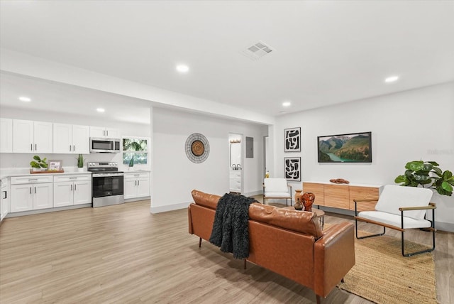 304 W 24th St, Sanford, FL 32771 - living area with light wood-type flooring, recessed lighting, and baseboards