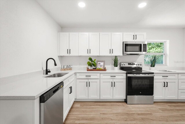304 W 24th St, Sanford, FL 32771 - kitchen with appliances with stainless steel finishes, a sink, white cabinetry, light countertops, and recessed lighting